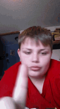 a young boy in a red shirt is giving a high five