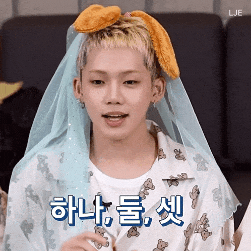 a young man wearing a blue veil and a shirt with teddy bears on it says lje