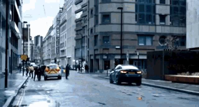 a car is driving down a city street next to a white van with a yellow stripe on the side