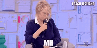 a woman is sitting in a chair holding a microphone and says trash italiano mh
