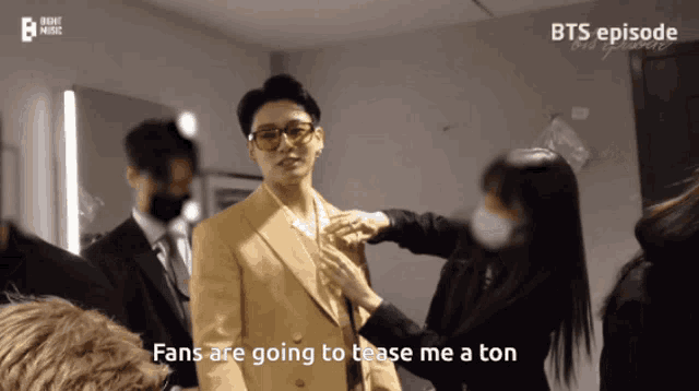 a man in a suit is being helped by a woman with the words fans are going to tease me a ton behind him