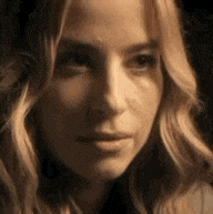 a close up of a woman 's face with blonde hair and a serious look on her face .