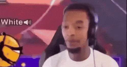 a man wearing headphones is sitting in front of a computer screen with a basketball in the background .