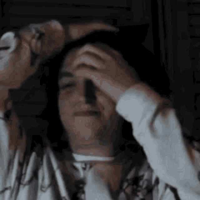 a close up of a person 's face with their hands on it .
