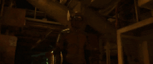 a man in a superhero costume is standing in a dark hallway