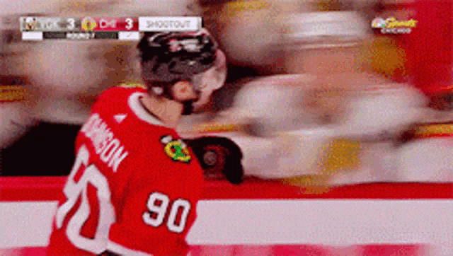 a hockey player in a red jersey with the number 90 on it