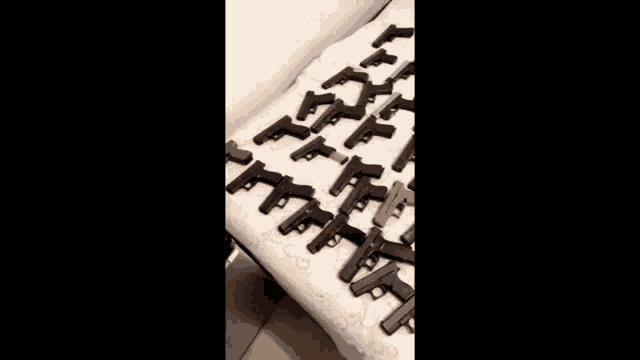 there are many different types of guns on the table .