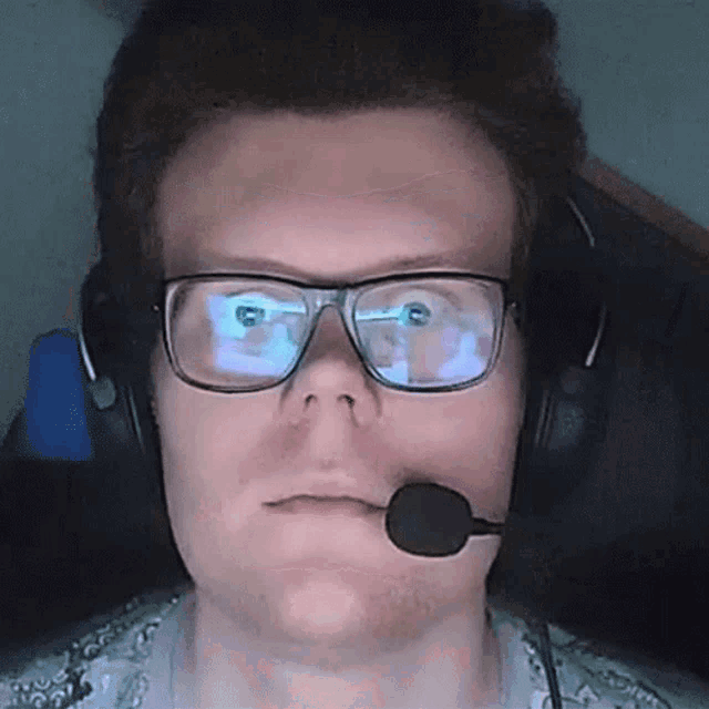 a man wearing glasses and headphones with a microphone on his mouth