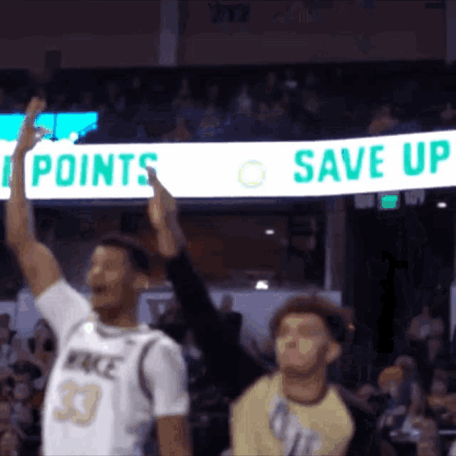 a basketball player with the number 33 on his jersey holds up his arms in the air