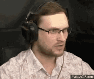a man wearing headphones and glasses is sitting in front of a computer .