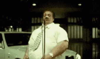 a man is singing into a microphone while wearing a tie .