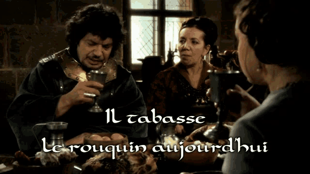 a man and a woman are sitting at a table with the words il tabasse le rouquin aujourdhui