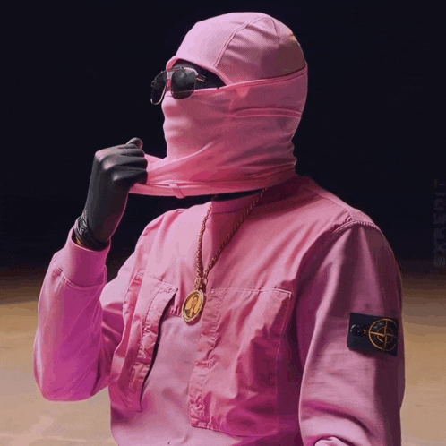 a man wearing a pink jacket with a stone island logo on the sleeve