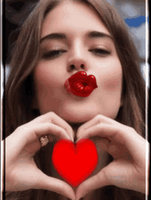 a woman with red lips making a heart shape