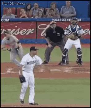 a baseball game is being played in front of an ad for rogers