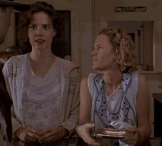 two women are sitting at a counter with a sign that says toilet on it
