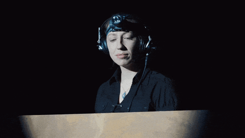 a woman wearing headphones and a headlight looks at something