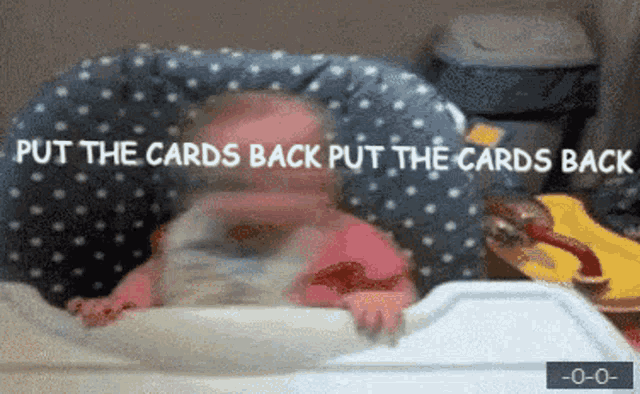 a baby sits in a high chair with the words put the cards back put the cards back