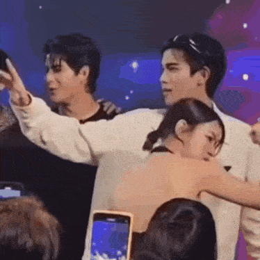 a man and a woman are hugging each other in front of a crowd .