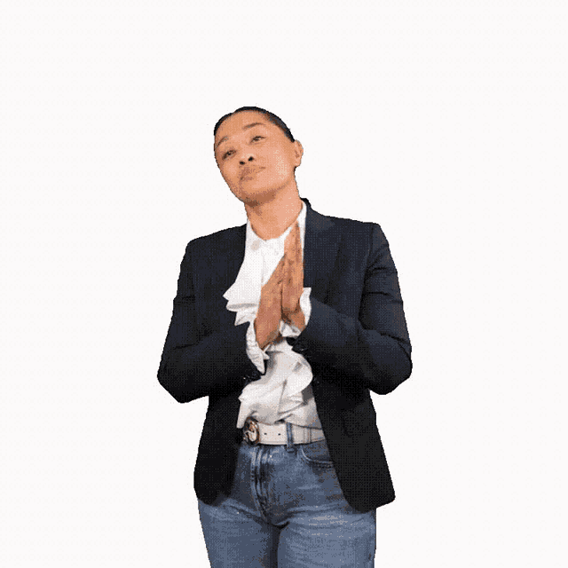 a woman in a black jacket and jeans is clapping her hands