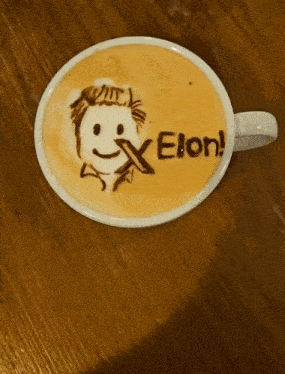 a cup of coffee with a drawing of elon on it
