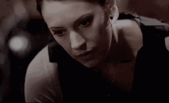 a close up of a woman 's face in a black tank top .