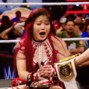 a woman with red hair is holding a wrestling championship belt with the letter m on it
