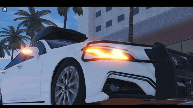 a white car is parked in front of a building with a palm tree in the background