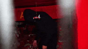 a person wearing a black hoodie with the letter a on the front