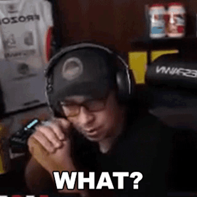 a man wearing headphones and glasses is asking what