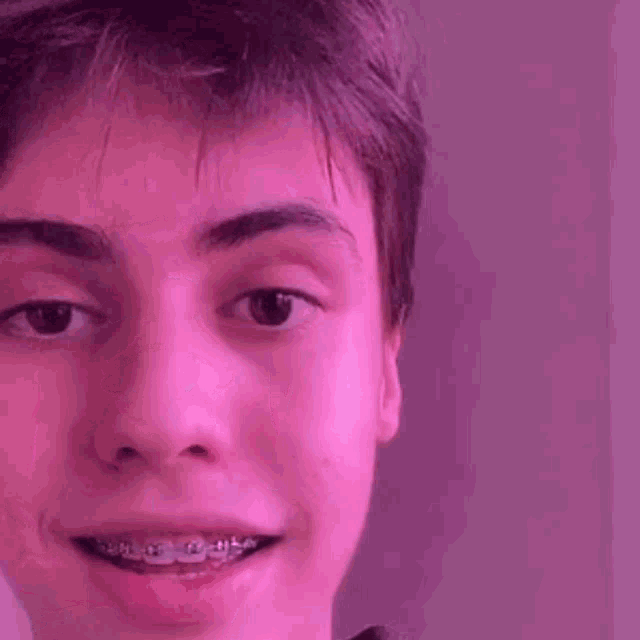 a close up of a person 's face with a pink background .