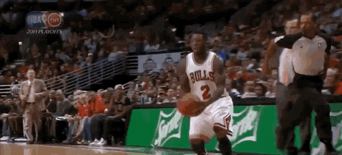 a basketball player wearing a bulls jersey dribbles the ball
