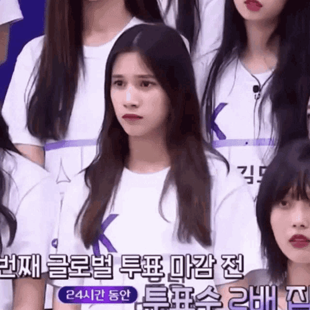 a girl in a white shirt with the letter k on the front
