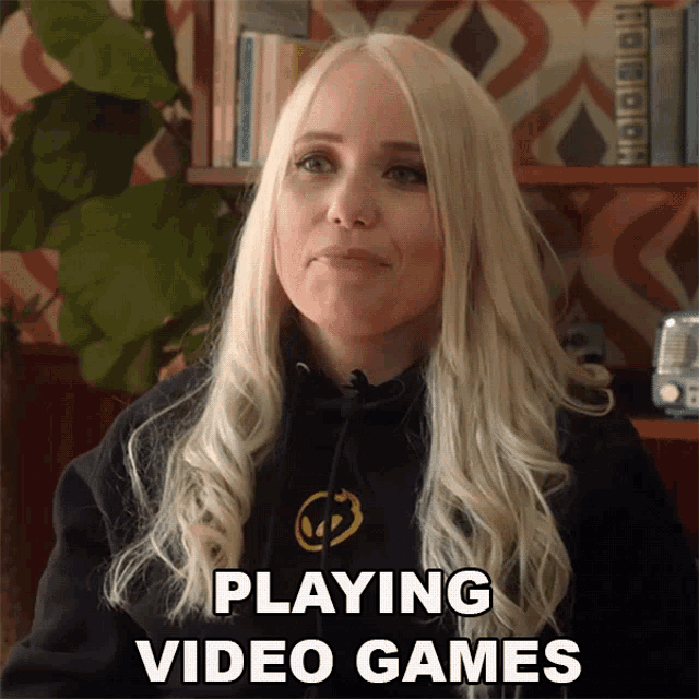a woman with blonde hair is wearing a black hoodie that says playing video games