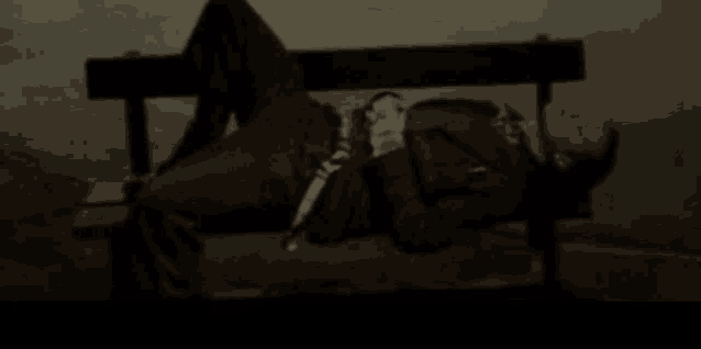 a man in a suit is laying on a park bench