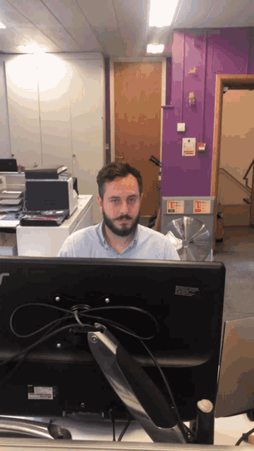 a man is sitting in front of a dell monitor