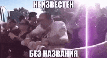 a man is being attacked by a crowd of people at a concert while a purple light is shining in the background .