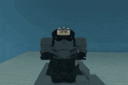 a statue of a knight with a sword and a cape is standing on a sandy surface .