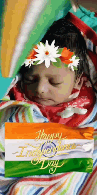 a baby wrapped in a blanket with a flower crown on her head
