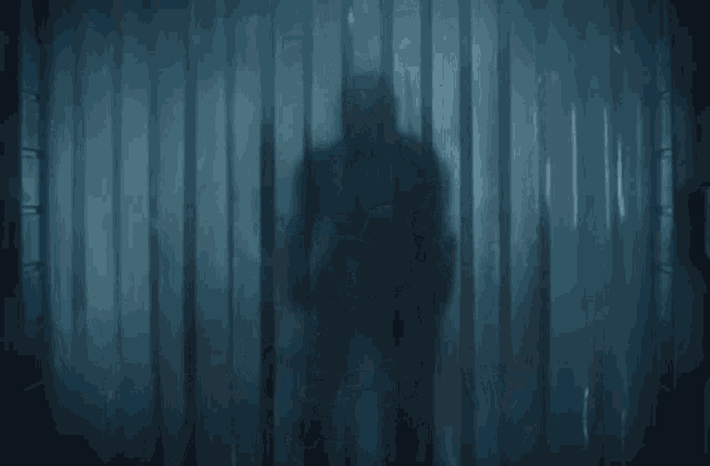 a man in armor is walking through a doorway with curtains