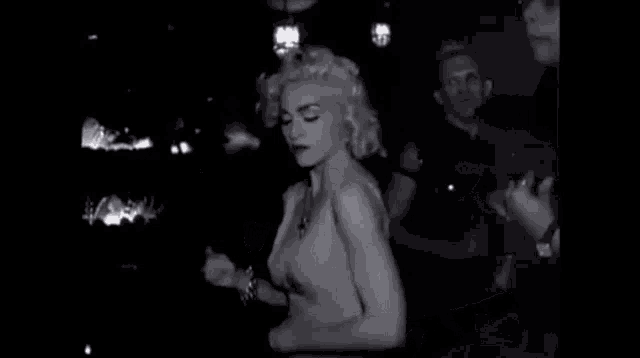 a black and white photo of a man and a woman dancing at a party .
