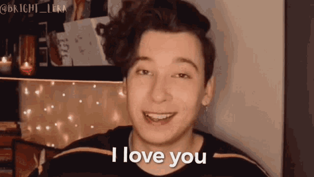 a young man says i love you in front of a shelf with candles