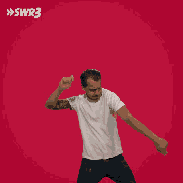 a man is dancing in front of a red background with the letters swr3 on it