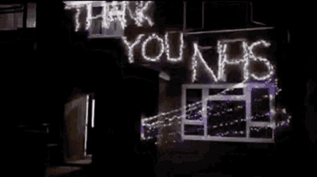 a house is decorated with lights and a sign that says `` thank you nns '' .