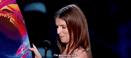 a woman is standing in front of a microphone and saying `` i 'm gonna go now . ''
