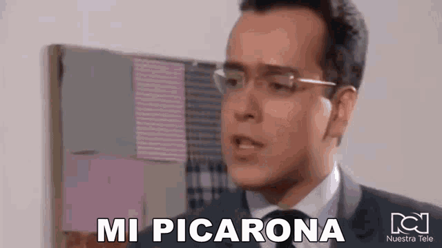a man in a suit and tie with glasses says mi picarona