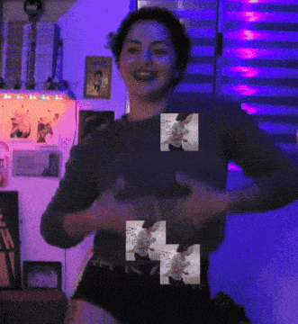 a woman is standing in front of a purple wall with a purple light behind her