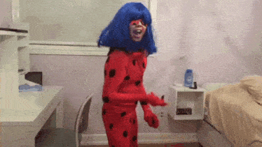 a person in a ladybug costume is dancing in a room .