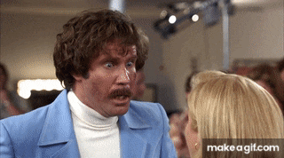 a man in a blue suit is talking to a woman in a crowd