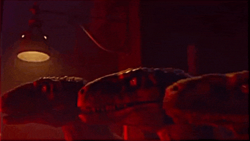 two dinosaurs are laying on a bed in a dark room with a lamp hanging from the ceiling .